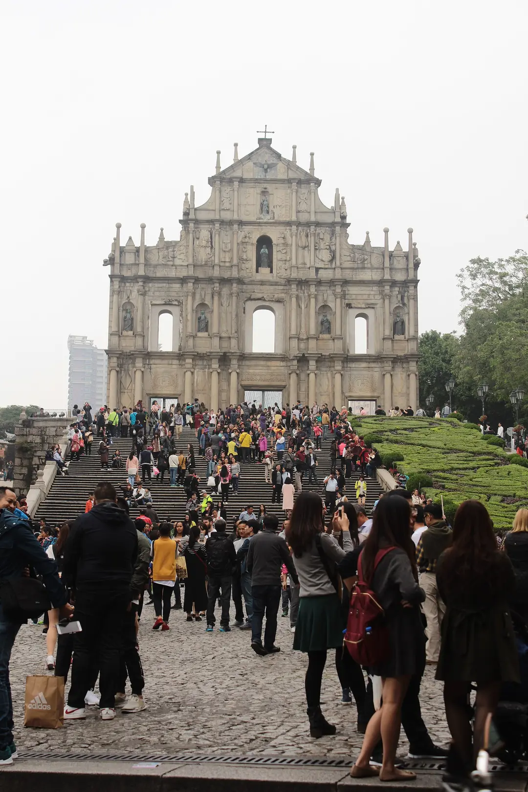 The stone facade of the Ruins of St. Paul's above a wide flight of steps crowded with visitors