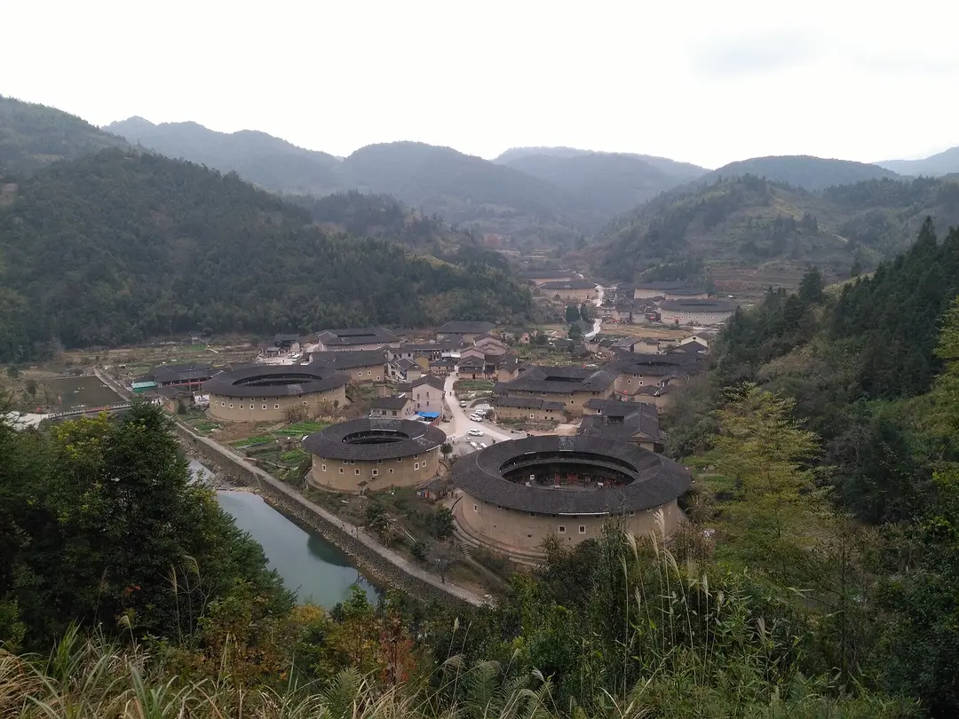 Round and square earthen tulou in a green mountain valley in Nanjing County, Fujian