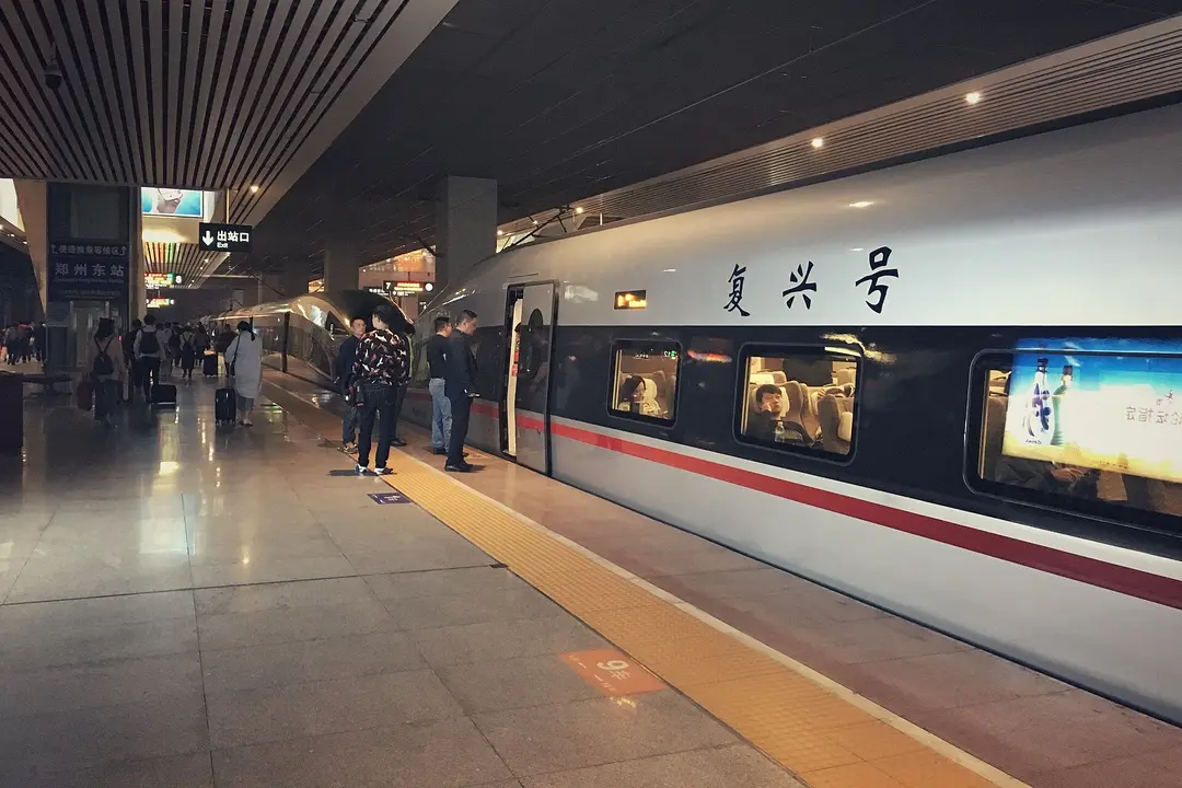A Fuxing high-speed train at the platform of Zhengzhou East station, with passengers waiting to board
