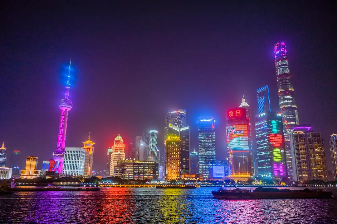The Oriental Pearl Tower and Lujiazui skyscrapers lit up across the Huangpu River at night