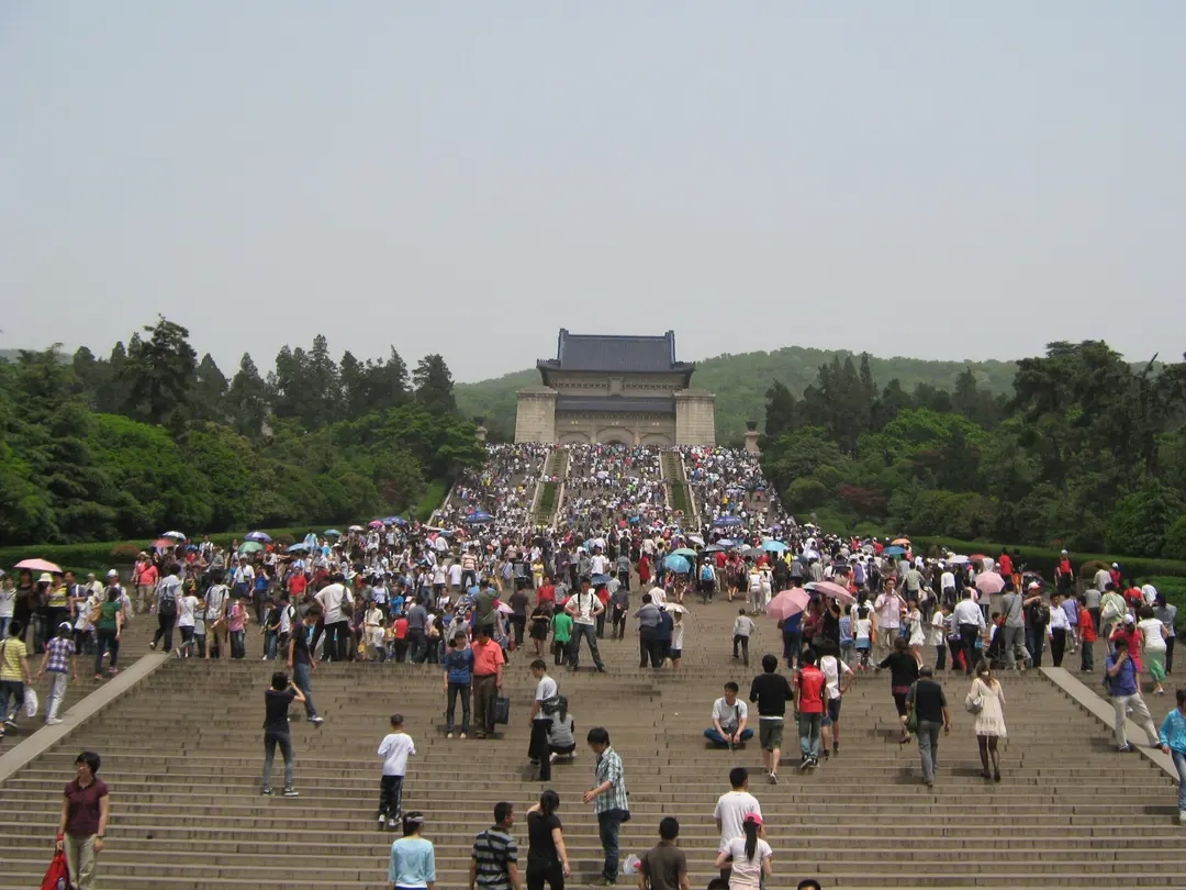 Crowds climbing the long stone stairway to the blue-roofed hall of Sun Yat-sen Mausoleum on Purple Mountain