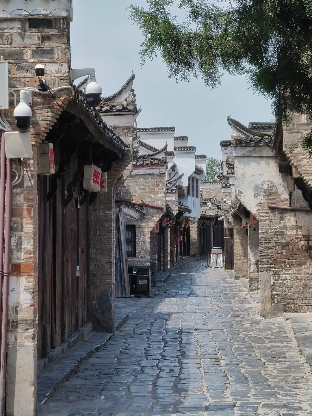 A stone-paved old street in Sanhe lined with grey brick houses and white stepped gables