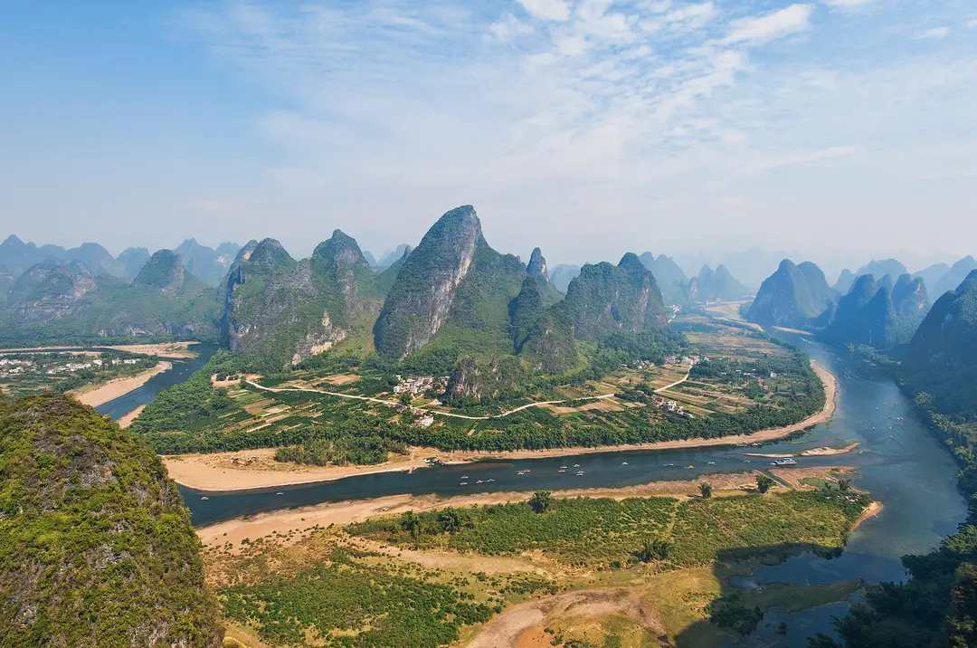 The Li River curving between steep green karst peaks and farmland near Yangshuo, seen from above