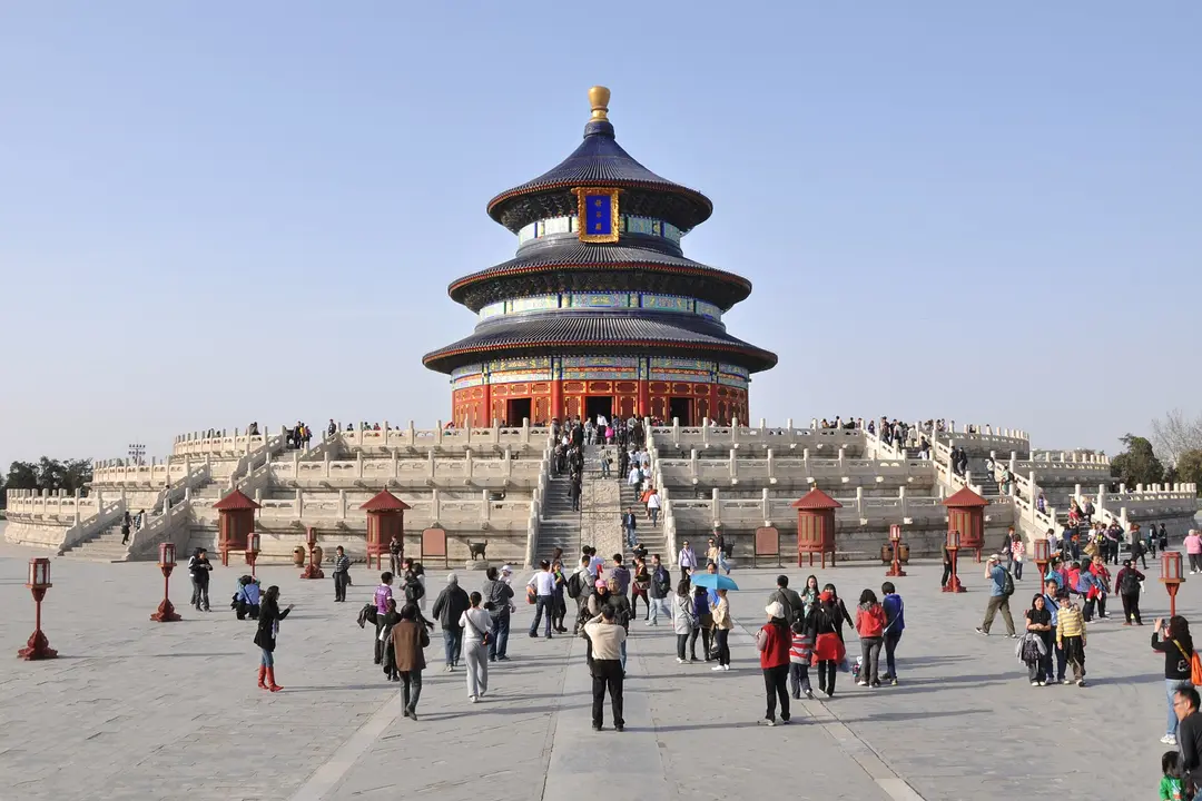 The round, triple-roofed Hall of Prayer for Good Harvests on its marble terrace, with visitors in the courtyard