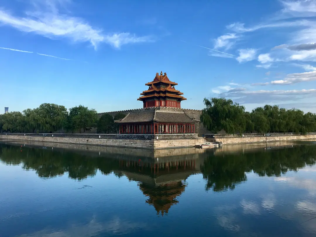 A corner tower of the Forbidden City reflected in the moat on a clear day