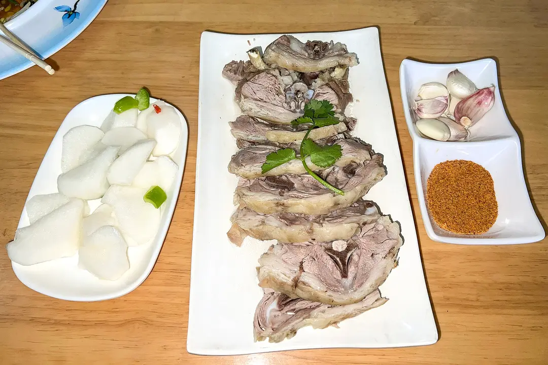 Sliced boiled lamb on the bone with garlic, spiced salt and radish, at a restaurant in nearby Jiayuguan