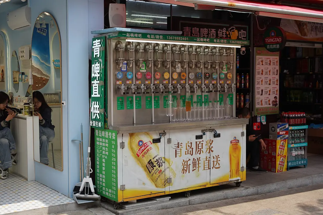 Self-service draft beer taps at a street-side beer shop in Qingdao
