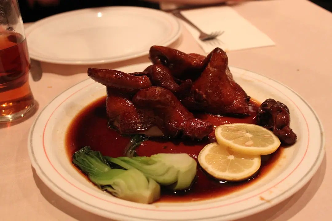 Roast squab pieces in a sweet soy glaze with lemon slices and bok choy