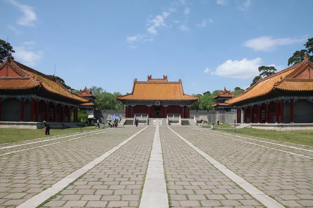 Stone-paved courtyard at Fuling tomb leading to a hall with a yellow-tiled roof, between two side halls