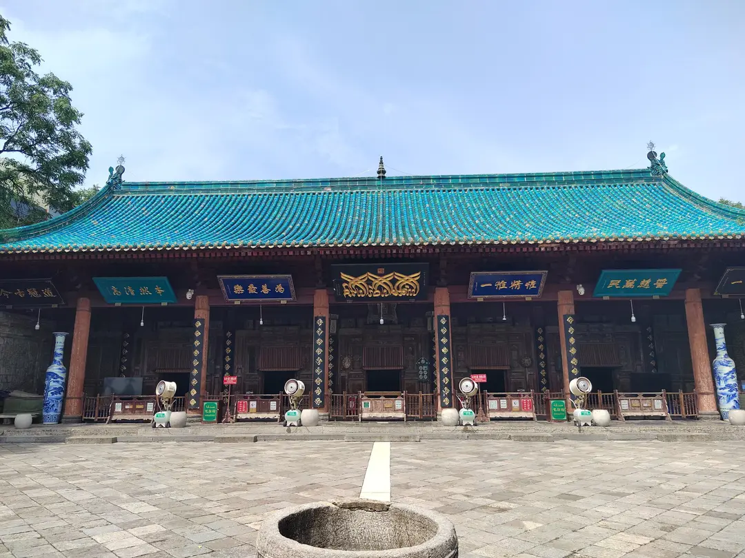 The prayer hall of the Great Mosque, a Chinese-style hall with a turquoise tiled roof, seen across a stone courtyard