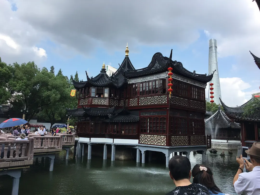 The Huxinting teahouse on stilts in its pond, with Shanghai Tower in the distance