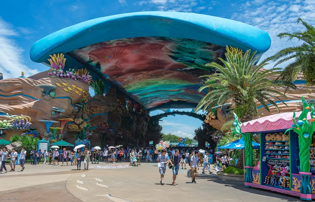 Visitors walking under a wave-shaped arch on the main avenue of Chimelong Ocean Kingdom