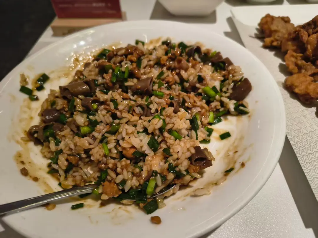 Rice covered with chopped sea worm and chives in a dark savory sauce