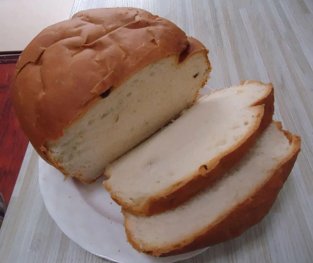 Large round loaf of bread with slices cut from it