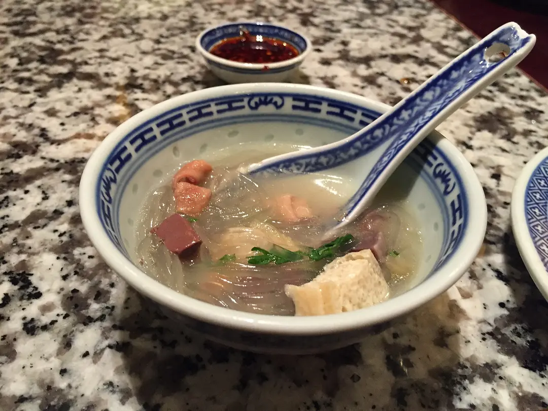 Bowl of duck blood and vermicelli soup with tofu puffs