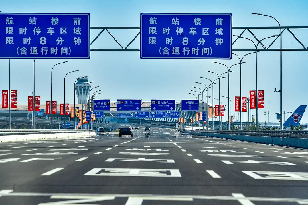 A car on the expressway approaching the terminal drop-off at Beijing Daxing International Airport