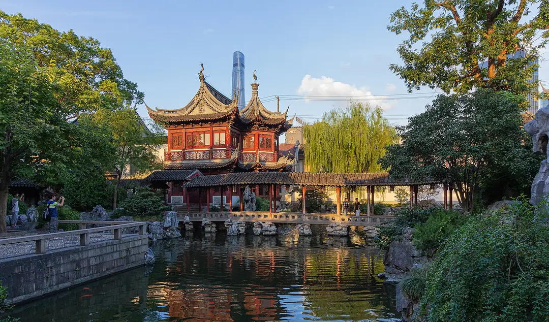 A two-storey pavilion with upturned eaves beside a pond and willow in Yu Garden